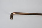 A close-up of a curved metal bar with a square mounting bracket, finished in a warm bronze or copper tone, shown against a plain light gray background.
